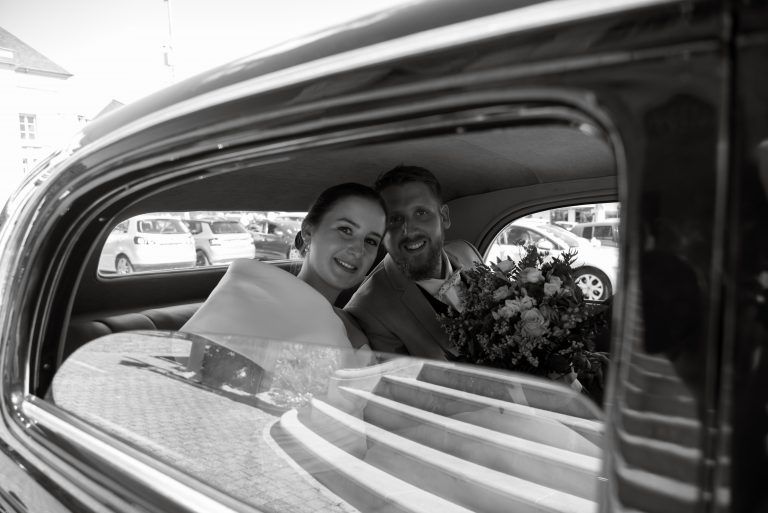 Photo de mariage : couple dans voiture en noir et blanc